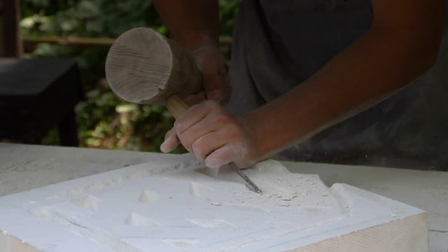 Medieval stonemason sculpting stone in a vintage Middle Ages workshop. Slow Motion