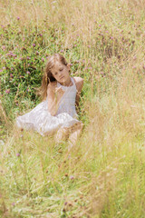 Fototapeta na wymiar Beautiful girl in wildflowers resting on a sunny day