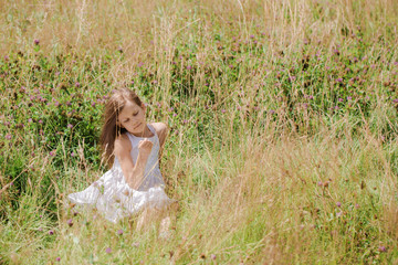 Fototapeta na wymiar Beautiful girl in wildflowers resting