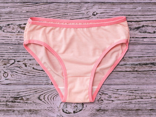 Beautiful pink women's panties on wooden background. Fashionable concept. Beautiful lingerie. The view from the top.