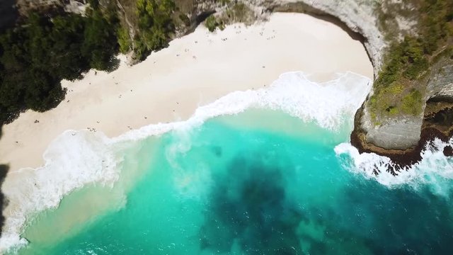 Drone shot high above the crystal clear blue water on KelingKing beach. Off the island of Nusa Penida, Indonesia.