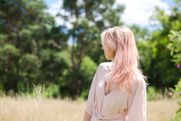 Beautiful young woman with pink hair in a pink costume