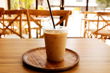 Ice coffee on a wooden table and orange light