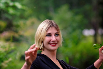 young girl in a black dress walks in a summer park