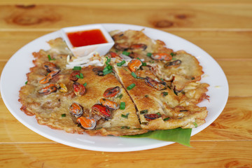 Fried noodle Thai style on a white plate on a brown table