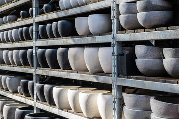 Rows of black gray and white large flower pots on shelves