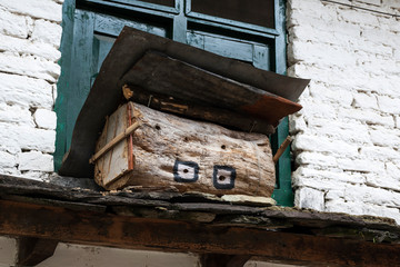 Wooden beehive set on roof of Tibetan house
