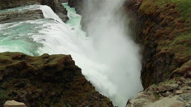 Massive waterfall located in the canyon of the Hvita River, Iceland. Slow motion shot showing falls into canyon and mist in the air.