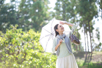 日傘をさす笑顔の中年女性