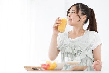 オレンジジュースを飲む女性