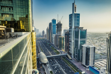 Skyscrapers and highways of a big modern city at sunset. Panoramic view on downtown Dubai, United Arab Emirates.