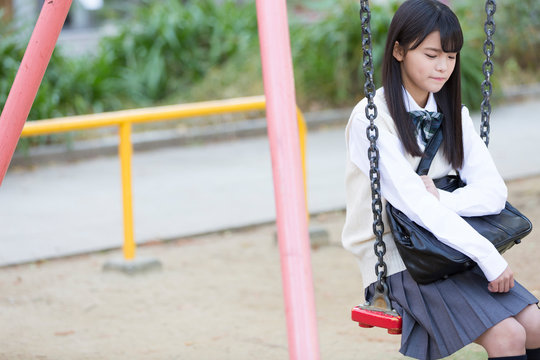 ブランコに乗る女子校生
