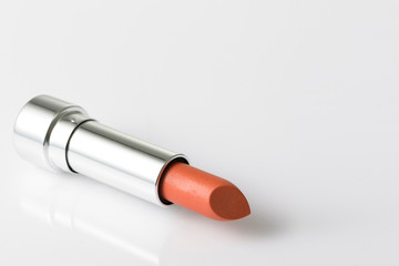 Lipstick lay on acrylic table with empty space on the right side