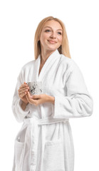 Beautiful young woman in bathrobe drinking coffee on white background
