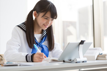 タブレット端末で勉強する女子校生