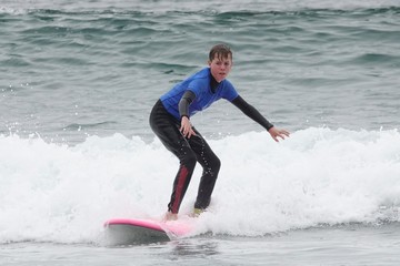 A. Boy rides a surfboard..