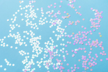 Holographic sparkles on blue pastel background. Festive trendy backdrop