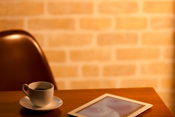 テーブルに置かれたコーヒーとタブレット