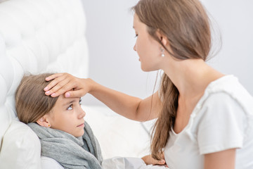 Obraz premium Mother touches the forehead of the child, checking the temperature