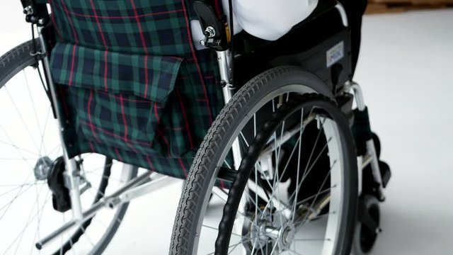 車椅子を押すスーツの女性