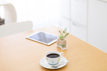 テーブルに置かれたコーヒーとタブレットPC