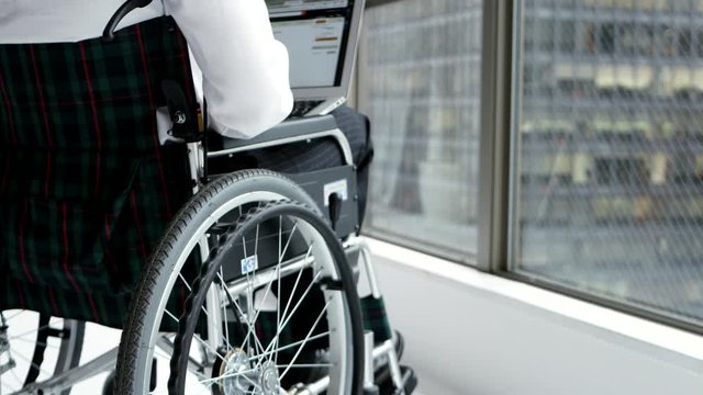 パソコンで作業をする車椅子の男性