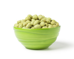 Wasabi crispy peanut snack balls in a green ceramic cup isolated on white background. With clipping path.