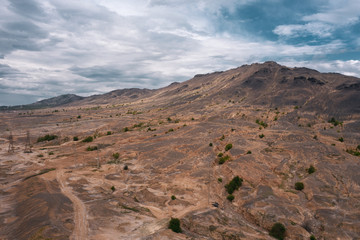 Natural landscape polluted by air emissions of copper production; dead vegetation and contaminationed terrain; problem of ecology, clean air and healthy; drone flying around mountain; aerial view