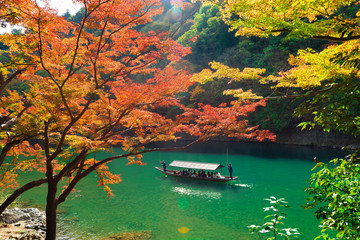 beautiful scene with tourist boat and Hozugawa river in Arashiyama park in autumn season, Kyoto,...