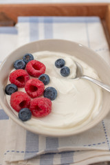 healhty greek Yogurt with fresh berries for breakfast on a table