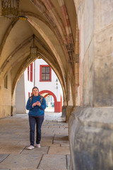Fototapeta na wymiar Lady walks in the streets of Europe using location app in her smartphone to search for attractive places
