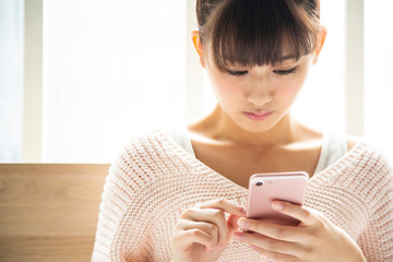 スマートフォンを見ている日本人女性