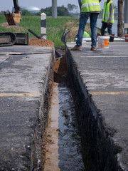 workers are installing concrete drains on the side of the road