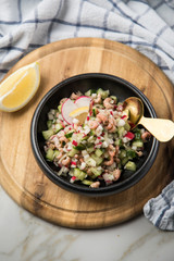 Norddeutscher Friesischer Nordseekrabben Salat in Schale mit Gurken, Radieschen, Zwiebeln, Dill und Zitronen auf Holz Brett