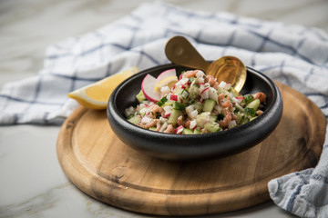 Norddeutscher Friesischer Nordseekrabben Salat in Schale mit Gurken, Radieschen, Zwiebeln, Dill und Zitronen auf Holz Brett