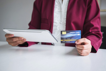Young woman consumer holding digital tablet, credit card and typing for online shopping and payment make a purchase on the Internet, Online payment, networking and buy product technology