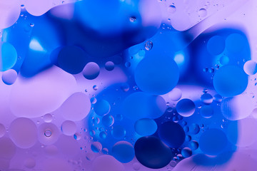 oily drops in water with colorful background, close-up 