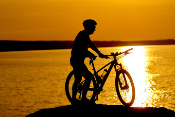 Fototapeta na wymiar Man cycling at beach on twilight summer season. Active Lifestyle Concept.