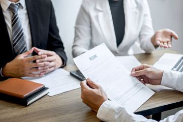 Employer or recruiter holding reading a resume with talking during about his profile of candidate, employer in suit is conducting a job interview, manager resource employment and recruitment concept