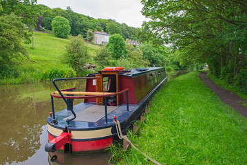 Obraz premium Narrowboat moored on a British canal in rural setting