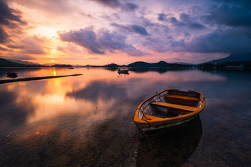Sunrise with boat and water reflection