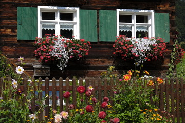 Fototapeta na wymiar Fenster an Bauernhaus aus Holz in den Alpen
