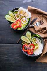 Top view vegetable salad with radishes, cucumbers, onions, sweet peppers and sesame oil. Healthy food. Vertical shot
