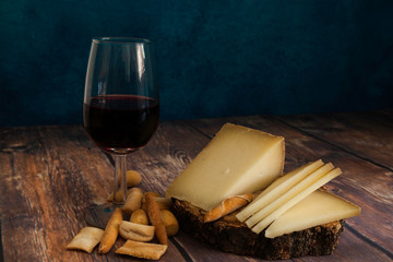 piece and slices of typical Spanish cheese and red wine