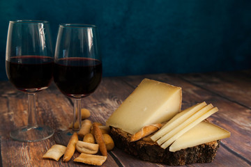 piece and slices of typical Spanish Manchego cheese, bread and wine