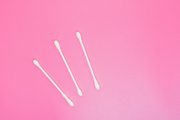 Ear sticks on a pink background. The concept of makeup removal and skin care. Space for text.
