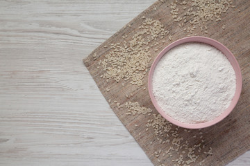 Gluten free rice flour in a pink bowl, top view. Flat lay, overhead, from above. Copy space.