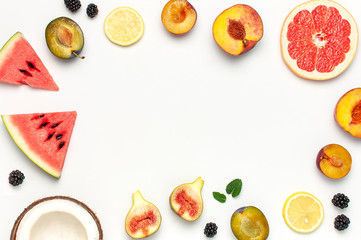 Tropical Summer Fruit Concept. Creative layout made of fresh ripe watermelon, peach, plum, fig, lemon, grapefruit and mint leaves on white background. Flat lay, top view, copy space. Food background
