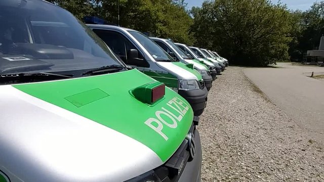 Panorama of a row of Parking Bavarian, German green Police Buses (Polizeibus). Major Police Unit in operation.