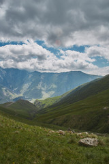 Fototapeta premium Large scenery of rocky mountains and green hills. Kazbegi Georgia
